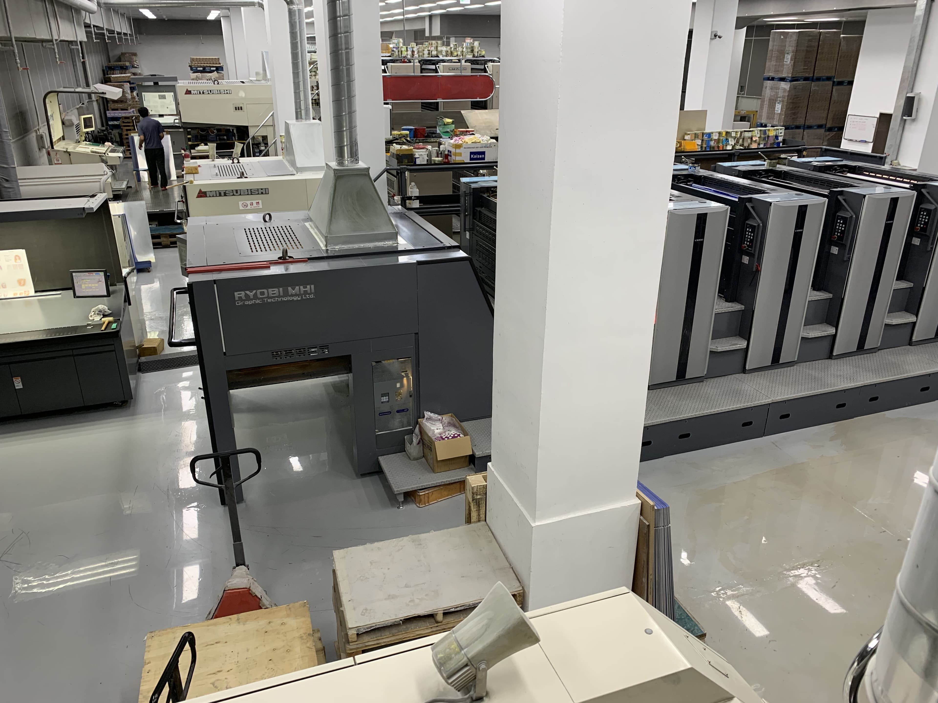 Wide view of the production floor with offset presses and staged paper stock