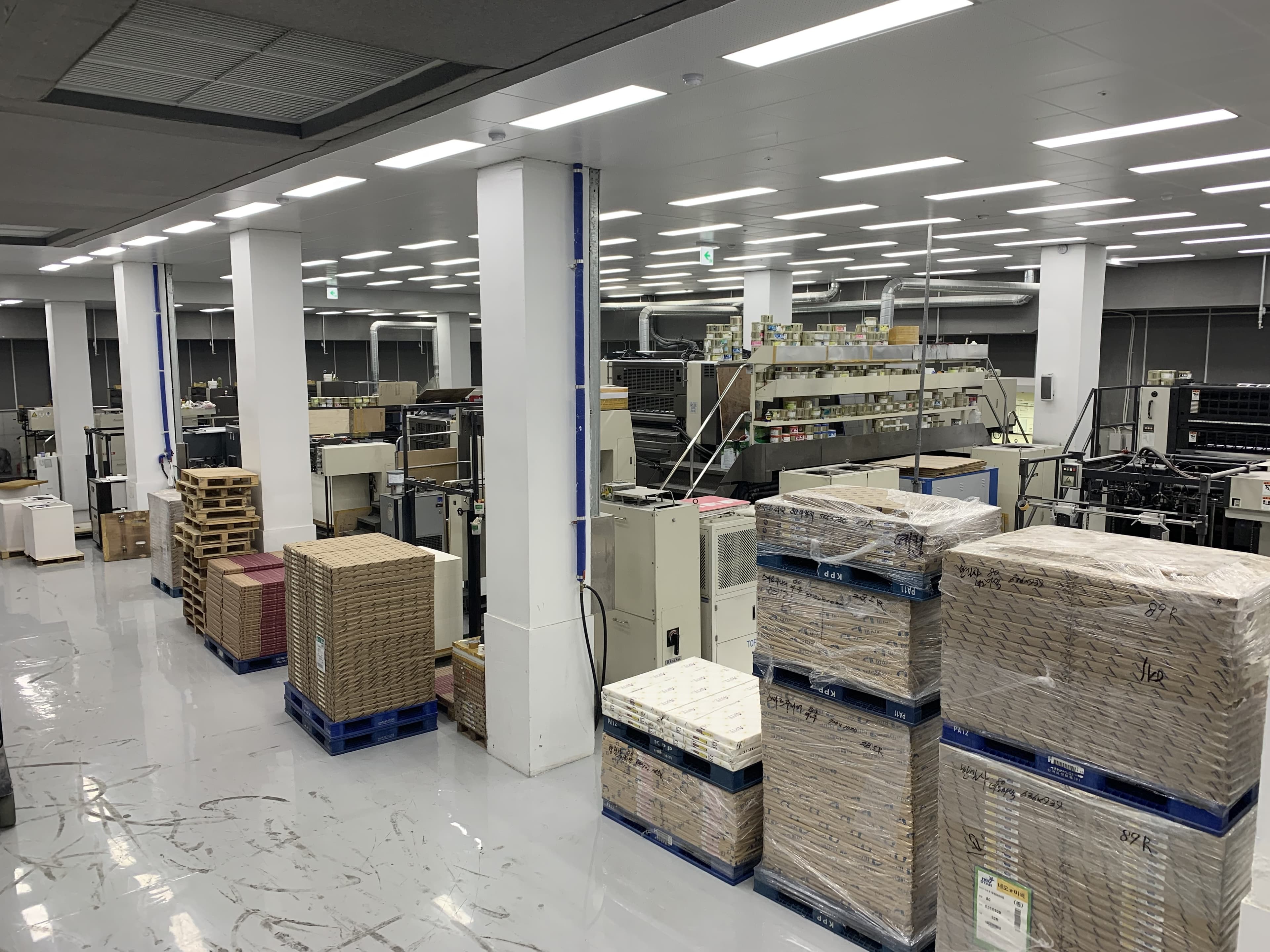 Wide view of the production facility floor, showing press lines and staged paper stock
